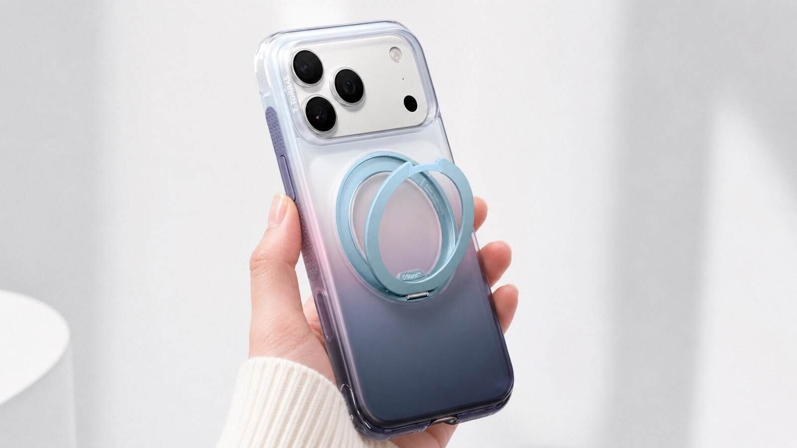 TORRAS Ostand Q3 Air case on iPhone 17 Pro Max shown in hand with a translucent blue-to-purple design and 360-degree rotating zinc-alloy stand extended