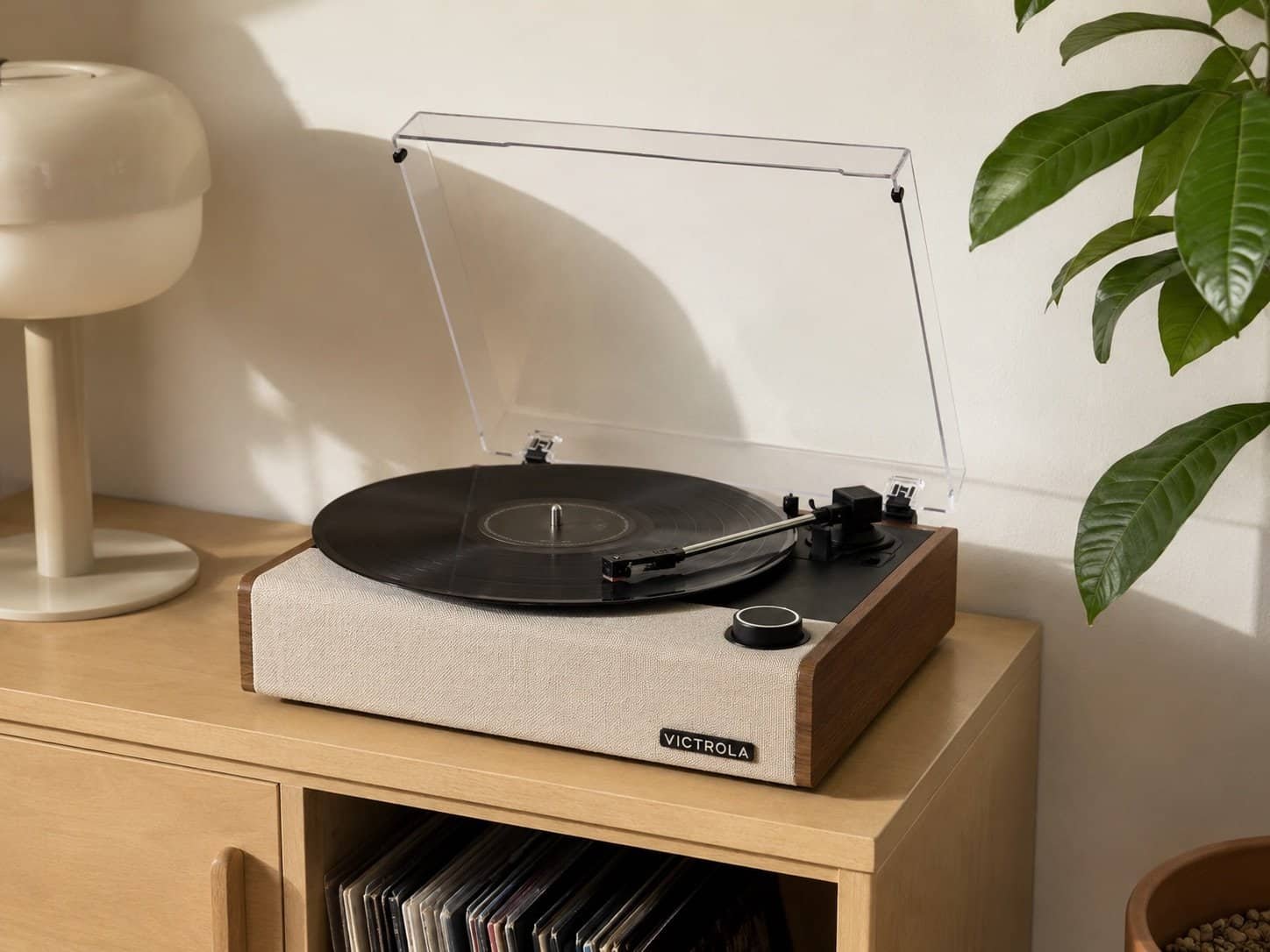 Victrola Eastwood II record player on wooden cabinet with vinyl records underneath