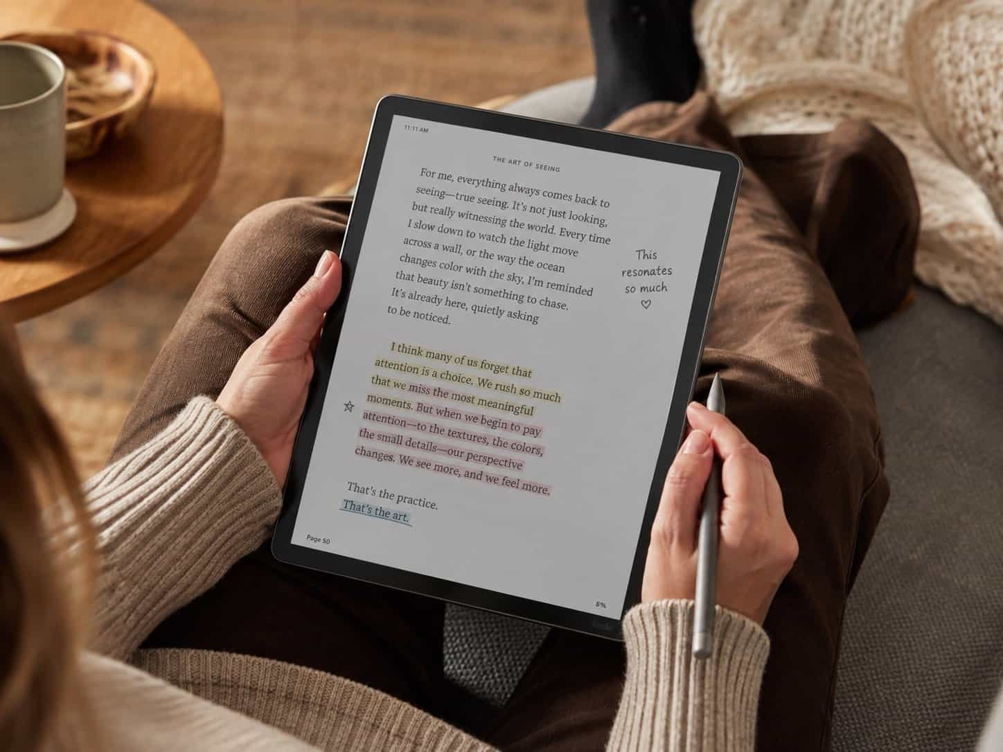 Kindle Scribe Colorsoft 11-inch color e-reader with Premium Pen beside an open book and handwritten notebook page